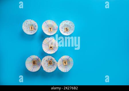 Il testo di un ragazzo con lettere in legno su sfondo blu, nascita del bambino ragazzo, vita nuova, biglietto di auguri per la famiglia per il neonato. Con spazio copia Foto Stock