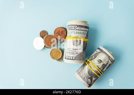 Banconote in dollari internazionali, le monete si trovano accanto a bande di gomma contorte di denaro. Luogo per un'iscrizione. Foto Stock