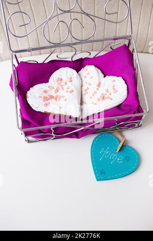 Biscotti a forma di cuore su un tovagliolo rosa iscrizione home Foto Stock