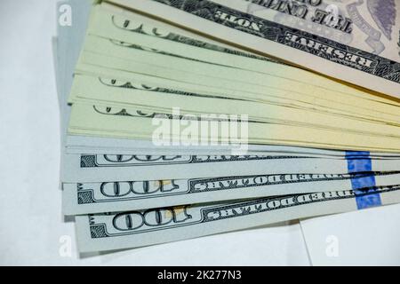 cisterna di banconote giace su un tavolo bianco. Un sacco di dollari, un mucchio di dollari. Foto Stock