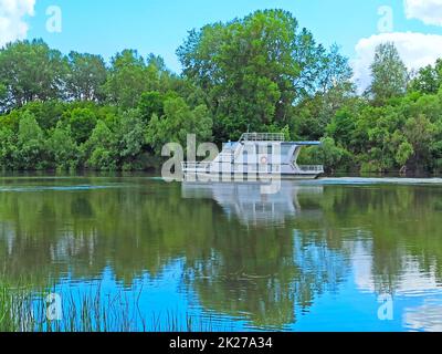 La barca veloce fa i turisti rotolanti grandi sul fiume. Gita in barca lungo il lago Foto Stock