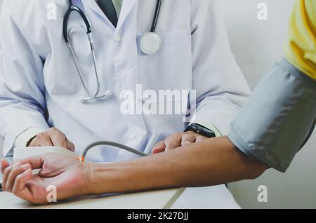 il medico misura la pressione sanguigna di un paziente maschio anziano. Foto Stock
