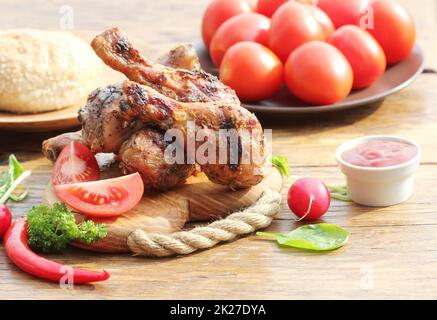 Grigliata di cosce di pollo con verdure sul bordo di taglio. Foto Stock