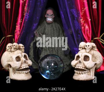 Cranio e sfera di cristallo su sfondo nero scena spettrale Foto Stock