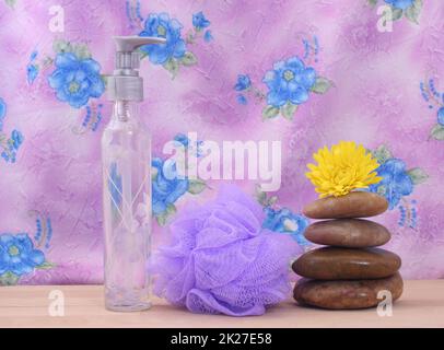 Pietre di sapone e massaggio con conchiglie di mare su sfondo floreale rosa Foto Stock