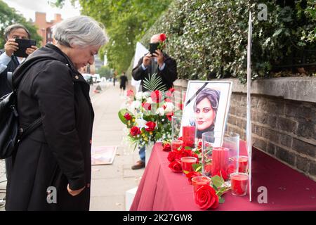 Londra, Regno Unito. 22nd Set, 2022. Gli iraniani di Londra protestano contro la morte di Mahsa Amini fuori dall'ambasciata iraniana, 16 Prince's Gate, Londra, SW7 1PT. Rose rosse deposte ad un tavolo commemorativo recante una fotografia di Mahsa Amini, noto anche come Jina Amini del patrimonio curdo, la giovane donna che è morto mentre nella custodia della polizia morale in Iran per una presunta violazione delle norme sontuose riguardanti l'hijab. Credit: Peter Hogan/Alamy Live News Foto Stock