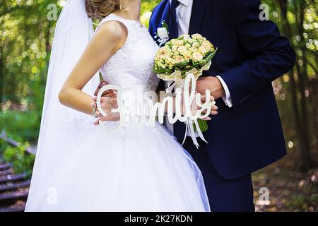 coppia che tiene un segno con la famiglia di parola Foto Stock