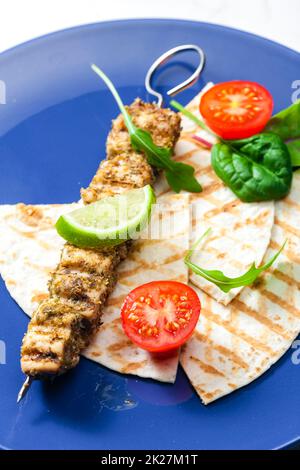 spiedino di carne alle erbe con pita pane, pomodori e lime Foto Stock