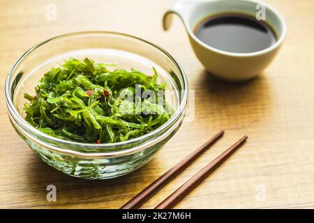 Wakame verde. Insalata di alghe e salsa di soia in ciotola. Foto Stock