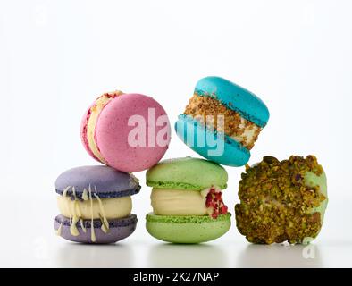 dolci francesi rotondi a base di macaron di farina di mandorle su sfondo bianco. Sapore di lampone, pistacchio e lavanda Foto Stock