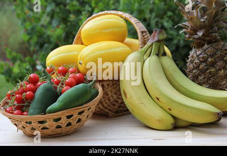 Raccolta di verdure estive - Meloni coreani Ginkaku con ananas, banane, peperoni Jalapeno e pomodoro Foto Stock