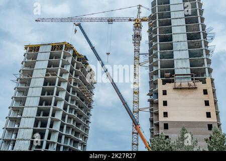 Cantiere con una gru.costruzione a lungo termine.Un nuovo edificio in costruzione, vista dal basso verso l'alto.grattacielo incompiuto,costruzione congelata.costruzione incompiuta di un residenziale a più piani Foto Stock