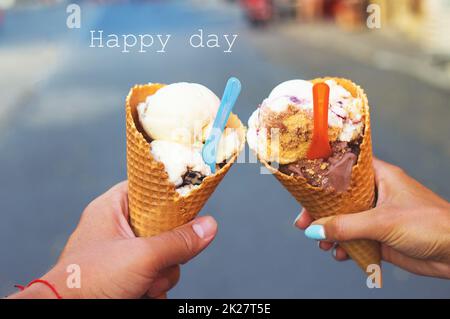 Bella luminosa gelato con sapori diversi nelle mani di un giovane Foto Stock