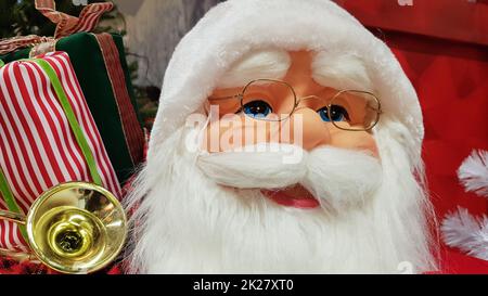 Il ritratto fotografico di una felice bambola giocattolo Babbo Natale con una borsa di regali simboleggia l'arrivo di Natale e Capodanno. Atmosfera festiva, concetto di vacanza. Foto Stock