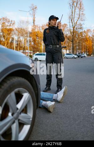 Poliziotto donna vicino auto crash conducente vittima Foto Stock