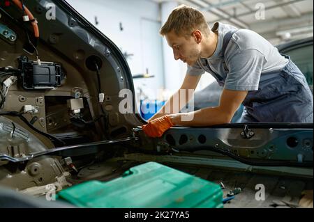 Vite di fissaggio dell'operatore durante la riparazione della carrozzeria Foto Stock