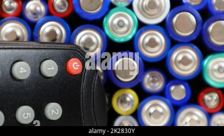 Telecomando TV con batterie alcaline AAA e AA monouso. Sostituzione della batteria, parti di ricambio. Concetto di riciclaggio. Molte batterie. Foto Stock