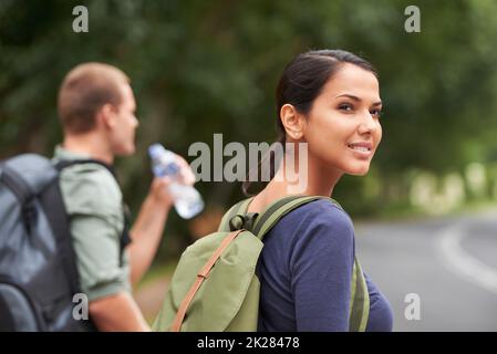 L'obiettivo del viaggio è quello di esplorare se stessi. Un'immagine candida di una donna che guarda in lontananza mentre suo marito beve acqua. Foto Stock