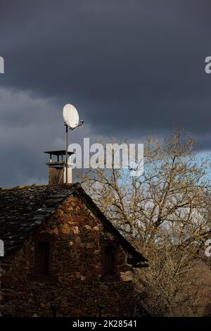 Vecchia casa con antenna satellitare sul tetto Foto Stock