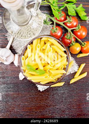 Penne in una ciotola di cocco con verdure a bordo Foto Stock