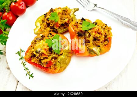 Pepe farcito con funghi e couscous in piatto su tavola leggera Foto Stock