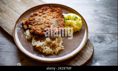 Cotoletta di maiale impanata ricoperta di pangrattato con purè di patate Foto Stock