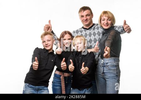 Ritratto di una grande famiglia ordinaria, tutti mostrano un pollice in su e guarda gioiosamente nella cornice Foto Stock