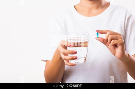 Donna tenere in mano farmaci per pillola pronto prendere farmaci con un bicchiere d'acqua Foto Stock