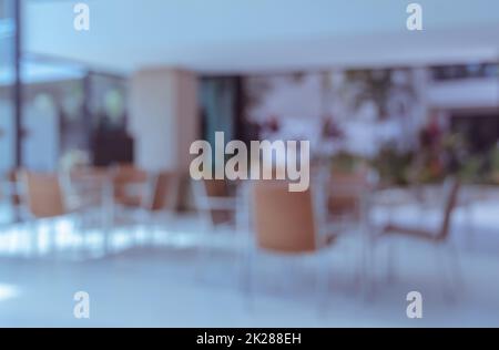Sedie vuote e tavolo in caffetteria, immagine di sfondo sfocata Foto Stock