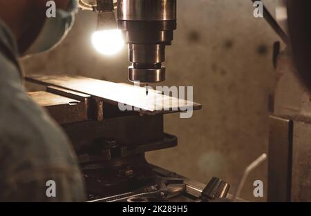 Fresatrice in prossimità di un operatore con maschera protettiva. Utensile per il taglio di pezzi metallici. Fresatrice verticale con fresa in carburo cementato. Industria siderurgica. Processo di fresatura. Foto Stock