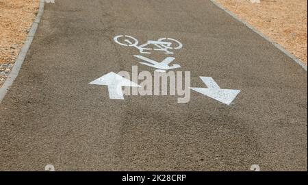 ampia pista ciclabile con grandi frecce bianche senza persone Foto Stock