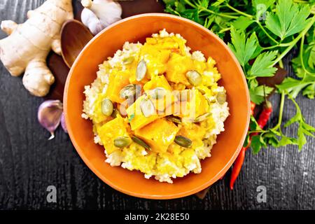 Miglio di porridge con zucca piccante in recipiente di argilla sulla parte superiore della tavola Foto Stock