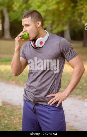 Giovane uomo che mangia una mela runner ritratto formato sport allenamento fitness Foto Stock
