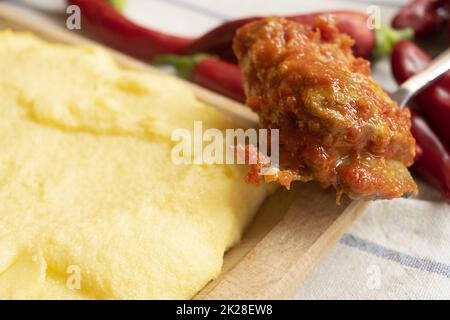 polenta con costolette di maiale in salsa di pomodoro Foto Stock