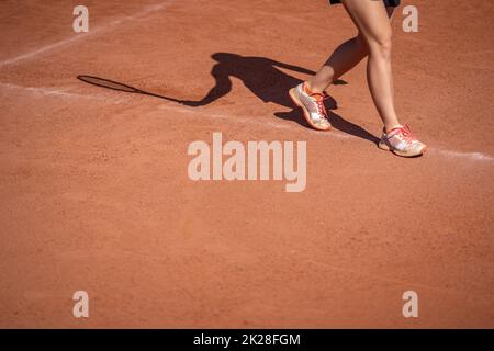 donna ombra giocatore di tennis su un campo di argilla all'aperto Foto Stock