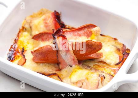 wurst in pancetta al forno con formaggio chedar Foto Stock