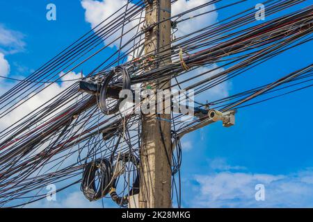 Cavo caos assoluto sul polo di potenza tailandese cielo blu Thailandia. Foto Stock