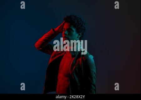 Ritratto di giovane uomo elegante in rosso neon Foto Stock