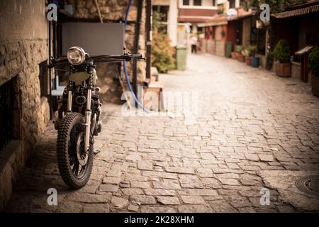 Moto d'epoca su una strada stretta Foto Stock