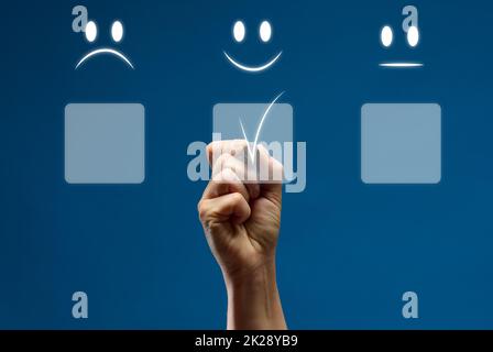 Concetto di servizio clienti e soddisfazione. La mano di una donna tocca lo schermo virtuale sull'icona di un'emoticon felice per ottenere la soddisfazione del servizio. Valutazione elevata Foto Stock