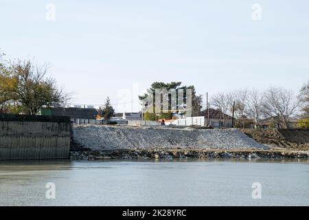 Rafforzamento dell'argine del fiume in città Foto Stock