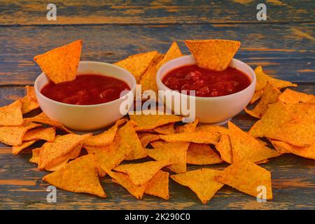 Chili corn-chips con salsa di salsa su sfondo di legno Foto Stock