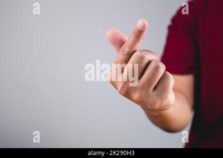 Cuore del dito in stile coreano. Segno d'amore isolato su sfondo bianco e grigio. Concetto di San Valentino. Foto Stock