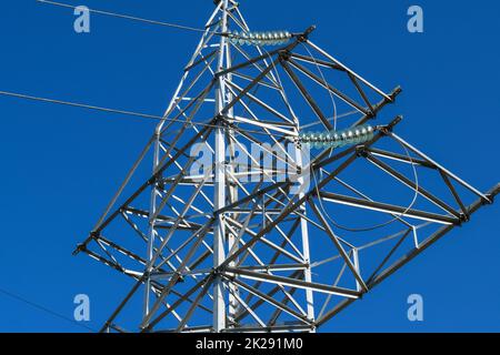 Supporta le linee elettriche ad alta tensione contro il cielo blu Foto Stock