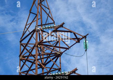 Supporta le linee elettriche ad alta tensione contro il cielo blu con nuvole. Industria elettrica Foto Stock