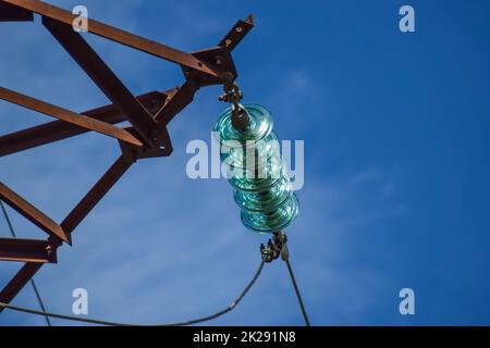 Prefabbricati di vetro isolatori ad alta tensione su pali linee elettriche ad alta tensione. Industria elettrica Foto Stock