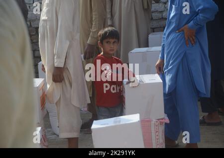 Peshawar, Pakistan. 22nd Set, 2022. Le persone colpite dalle inondazioni ricevono aiuti di soccorso distribuiti dalla Fondazione al Khidmat nel distretto di Nowshera, villaggio di Garhi Momin, provincia di Khyber Pakhtunkhwa. (Foto di Hussain Ali/Pacific Press) Credit: Pacific Press Media Production Corp./Alamy Live News Foto Stock