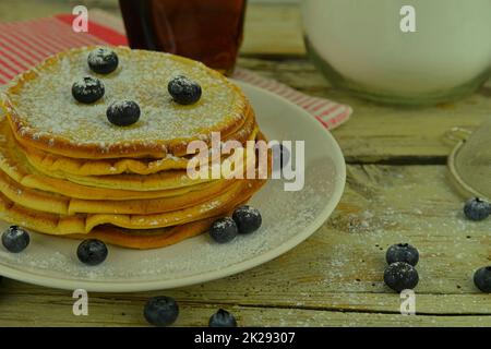 Pancake con mirtilli, sciroppo d'acero su un rustico sfondo bianco Foto Stock