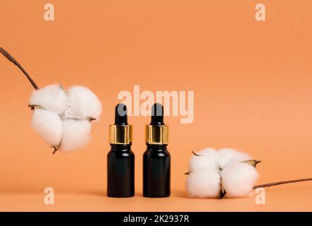 bottiglia di vetro nero con contagocce per cosmetici su fondo arancione. Confezionamento per gel, siero, pubblicità e promozione. Prodotti biologici naturali. Beffa Foto Stock