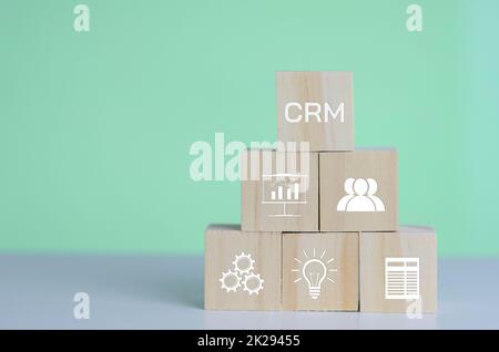 Cubi di legno con CRM Customer Relationship Management Automation System simbolo sullo sfondo e copy space.Business concetti. Foto Stock